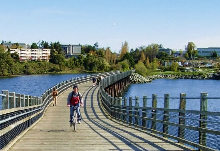 A person biking on the galloping goose trail in Victoria, BC.